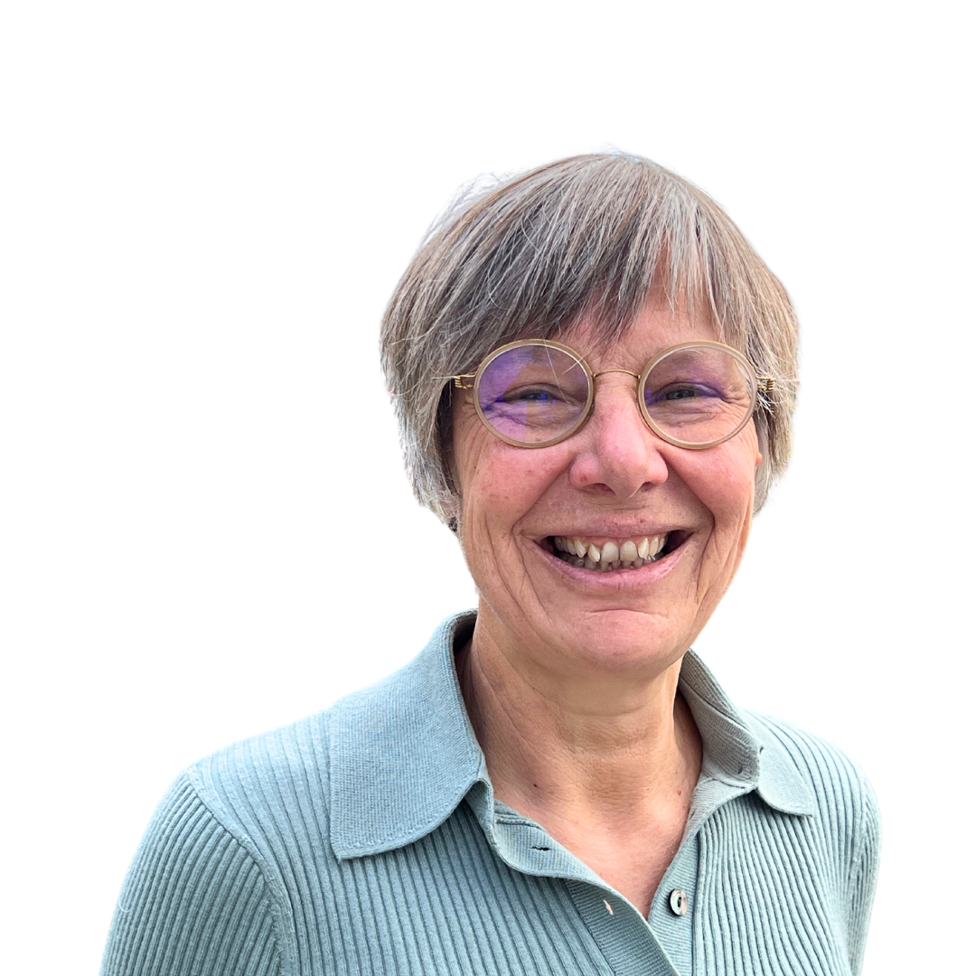 Portrait of a smiling older woman with short gray hair and round glasses, representing a 20-year migraine journey.