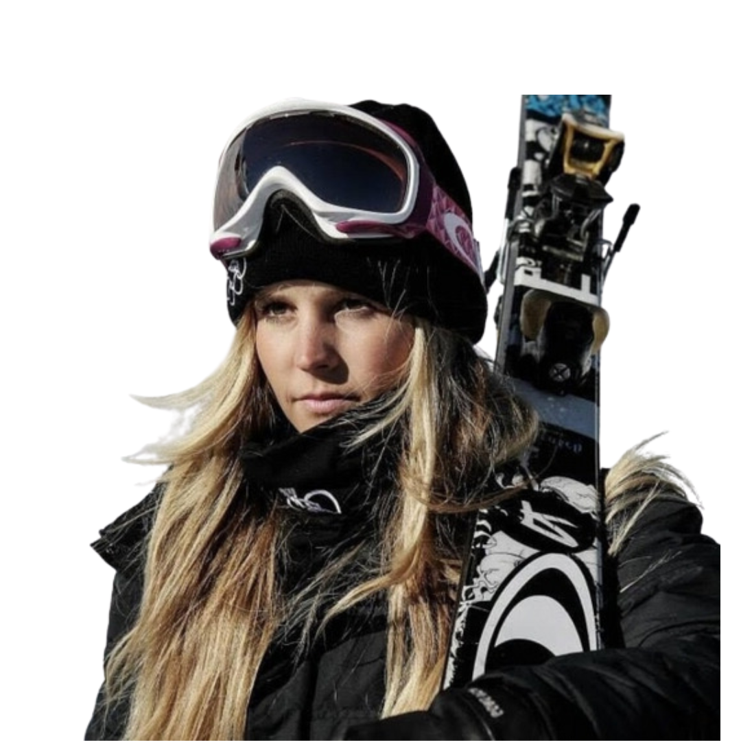 Anna in ski gear with long blonde hair, goggles on her head, and skis over her shoulder against a plain white background.